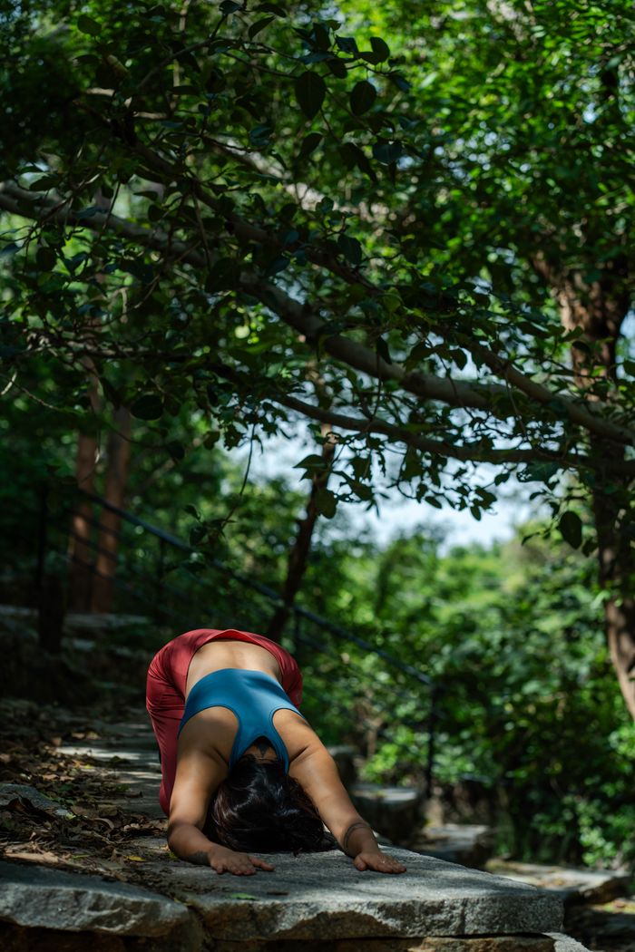 Mastering the First Impression: Your intriguing post title goes here Woman practicing yoga outdoors on stone steps, surrounded by lush greenery.